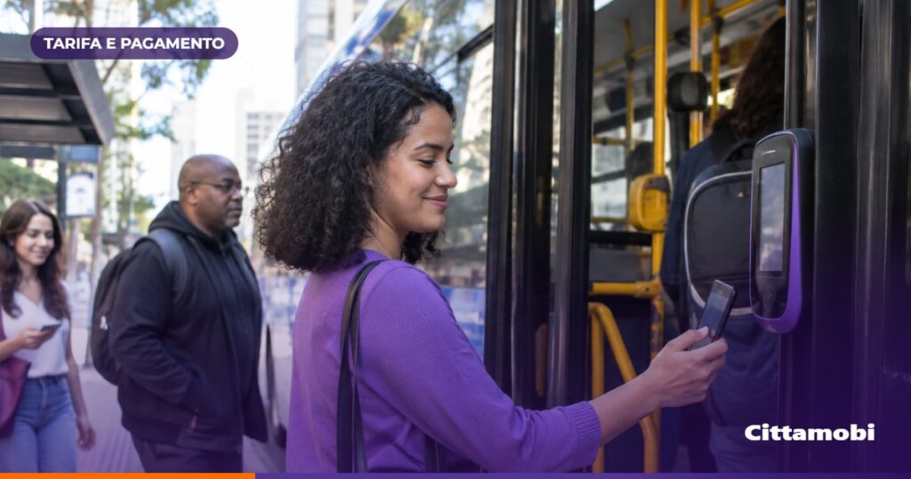 Passageiros em um ponto de São Paulo enquanto um ônibus se aproxima e uma pessoa segura o celular.
