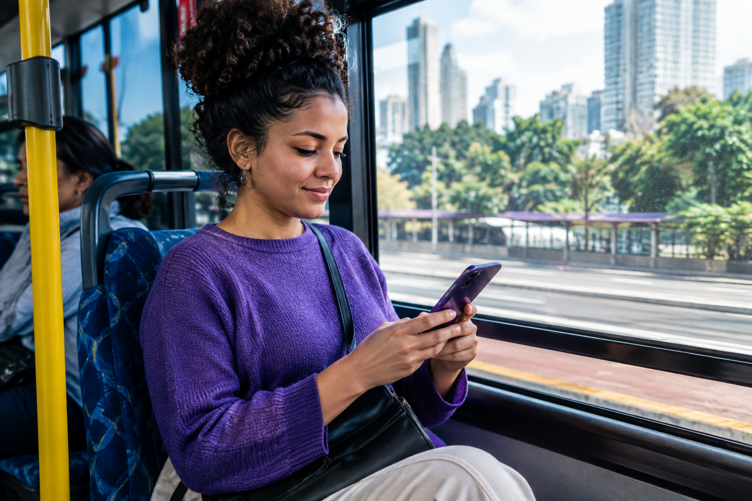 Passageira acompanha a viagem pelo celular dentro de um ônibus