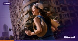 Pessoas em um ponto de São Paulo observam a chegada de um ônibus enquanto consultam o celular